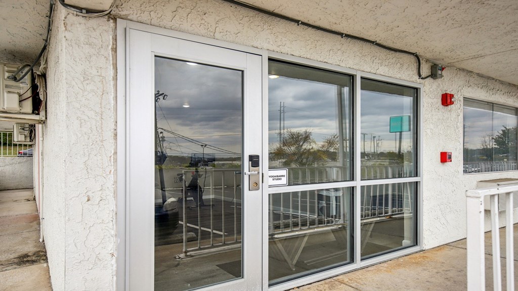 A white door with a glass window and a metal grill.