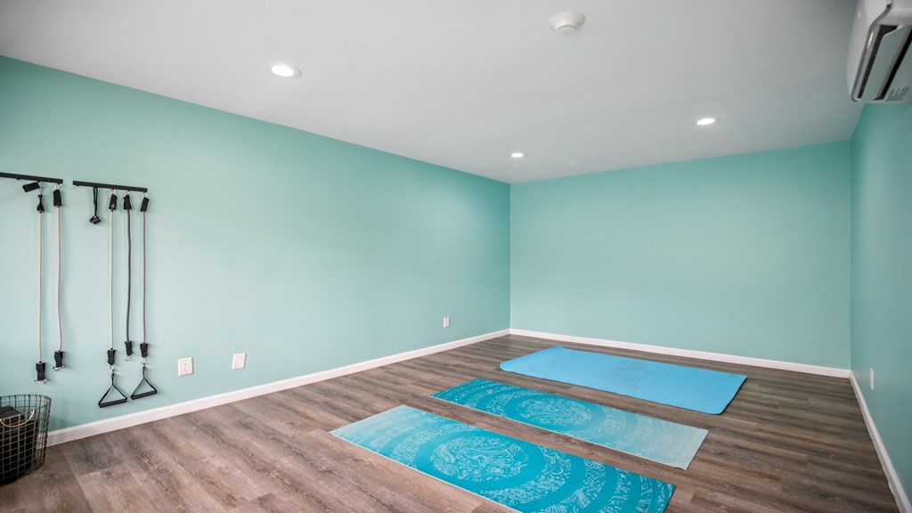 A room with a yoga mat on the floor.