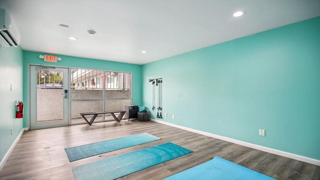 A yoga studio with a blue mat on the floor.