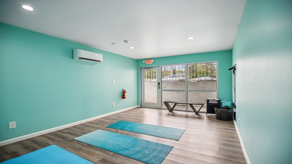 A yoga studio with blue mats on the floor.