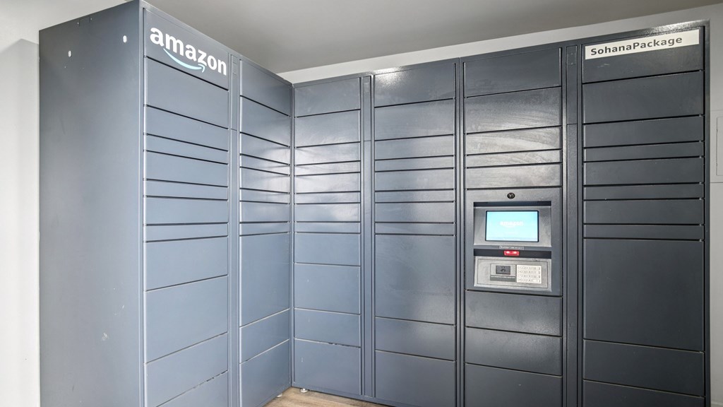 A row of Amazon storage lockers are lined up in a room.