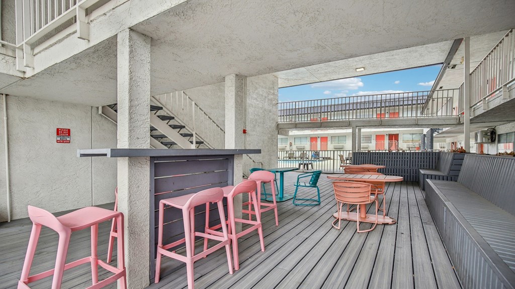 A patio with a bar and chairs.