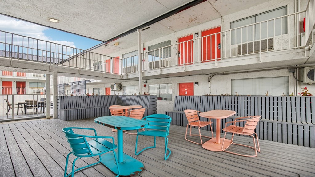 A balcony with a table and chairs.