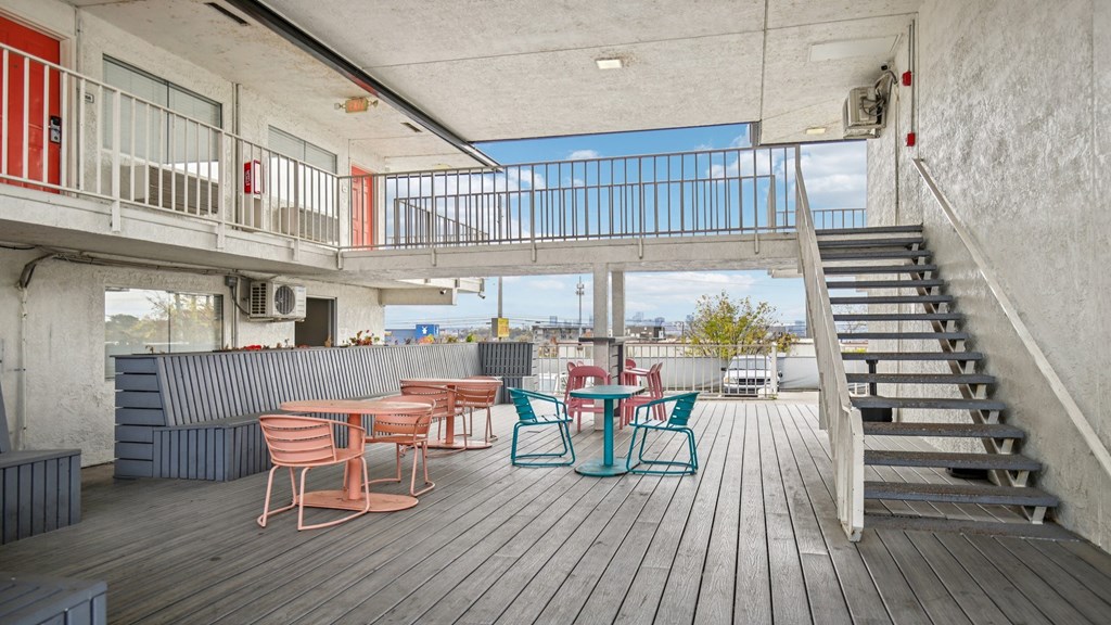 A wooden deck with chairs and a table.