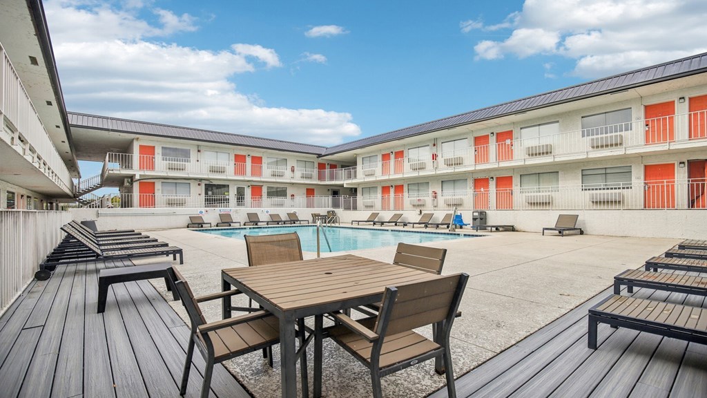 A wooden table and chairs are set up on a wooden deck.