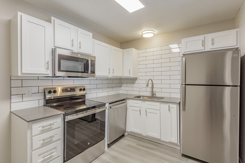 A kitchen with white cabinets and stainless steel appliances.