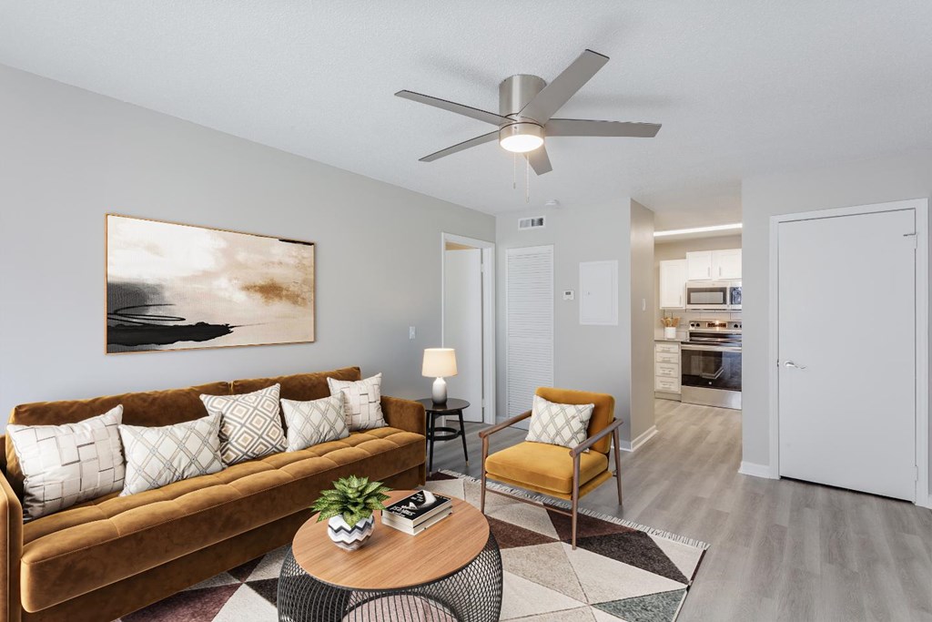 A living room with a brown couch, a coffee table, and a painting on the wall.