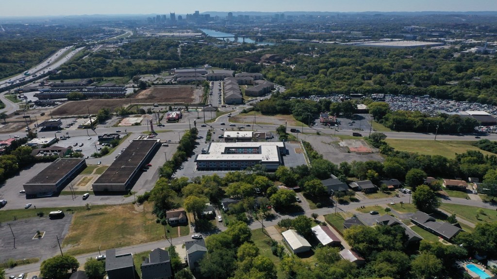 An aerial view of a large industrial area with buildings, roads, and a body of water in the distance.