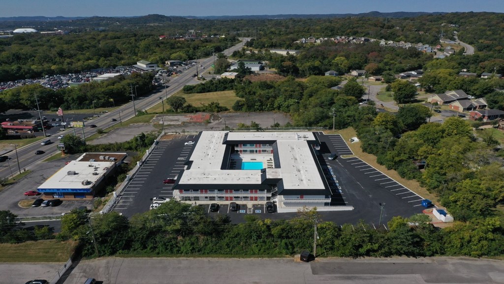 An aerial view of a large building with a parking lot in front.