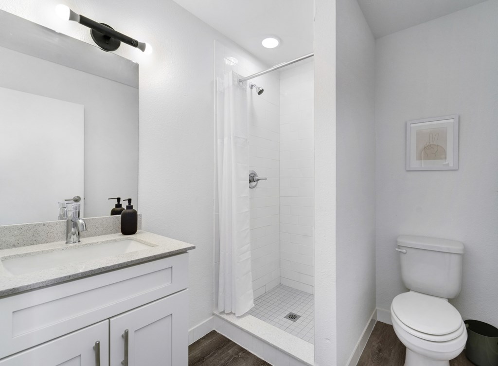 A white bathroom with a walk in shower.