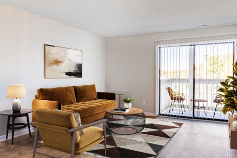A living room with a yellow sofa and a painting on the wall.