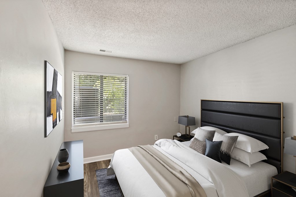 A bedroom with a large bed and a painting on the wall.