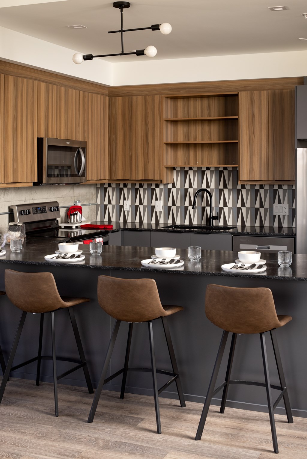 A modern kitchen with a bar area featuring two stools.at Damask, Ontario