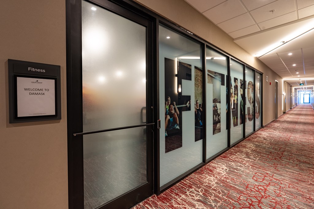A hallway with a sign that says "Fitness Welcome to Damask.".