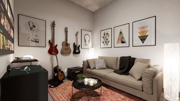 A living room with a couch, a coffee table, and a wall with framed pictures and guitars.