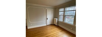 A room with a door, a window, and a radiator.