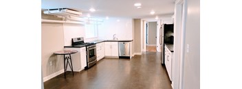 A kitchen with white cabinets and a black countertop.