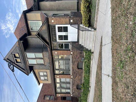 A house with a brown brick exterior and a white garage door.