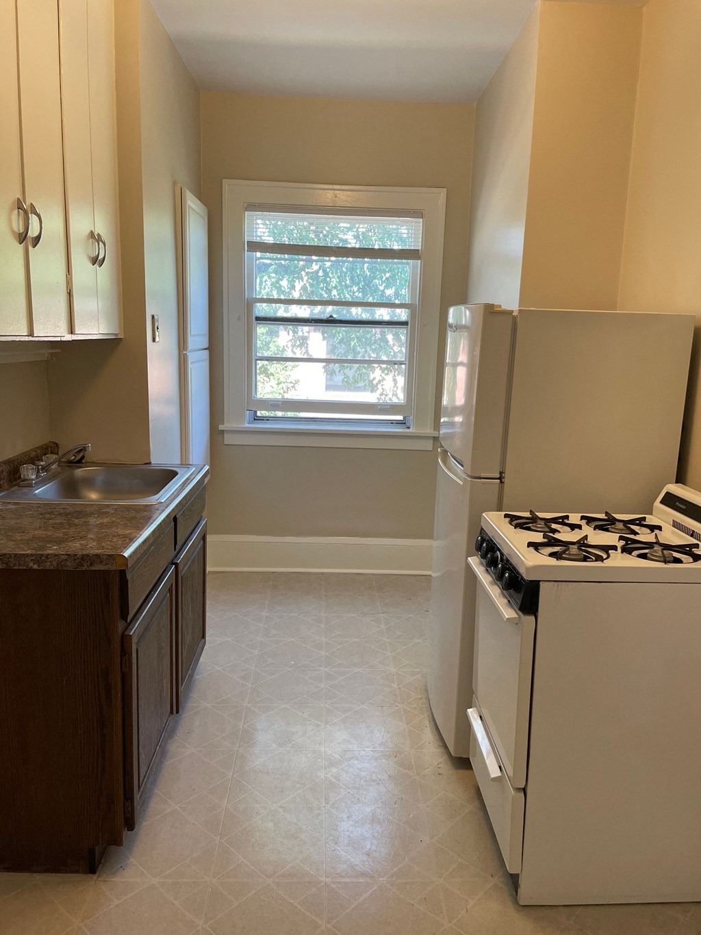 A kitchen with a white stove and a window.