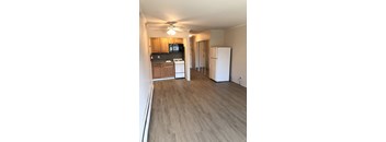 A kitchen with wooden cabinets and a white fridge.