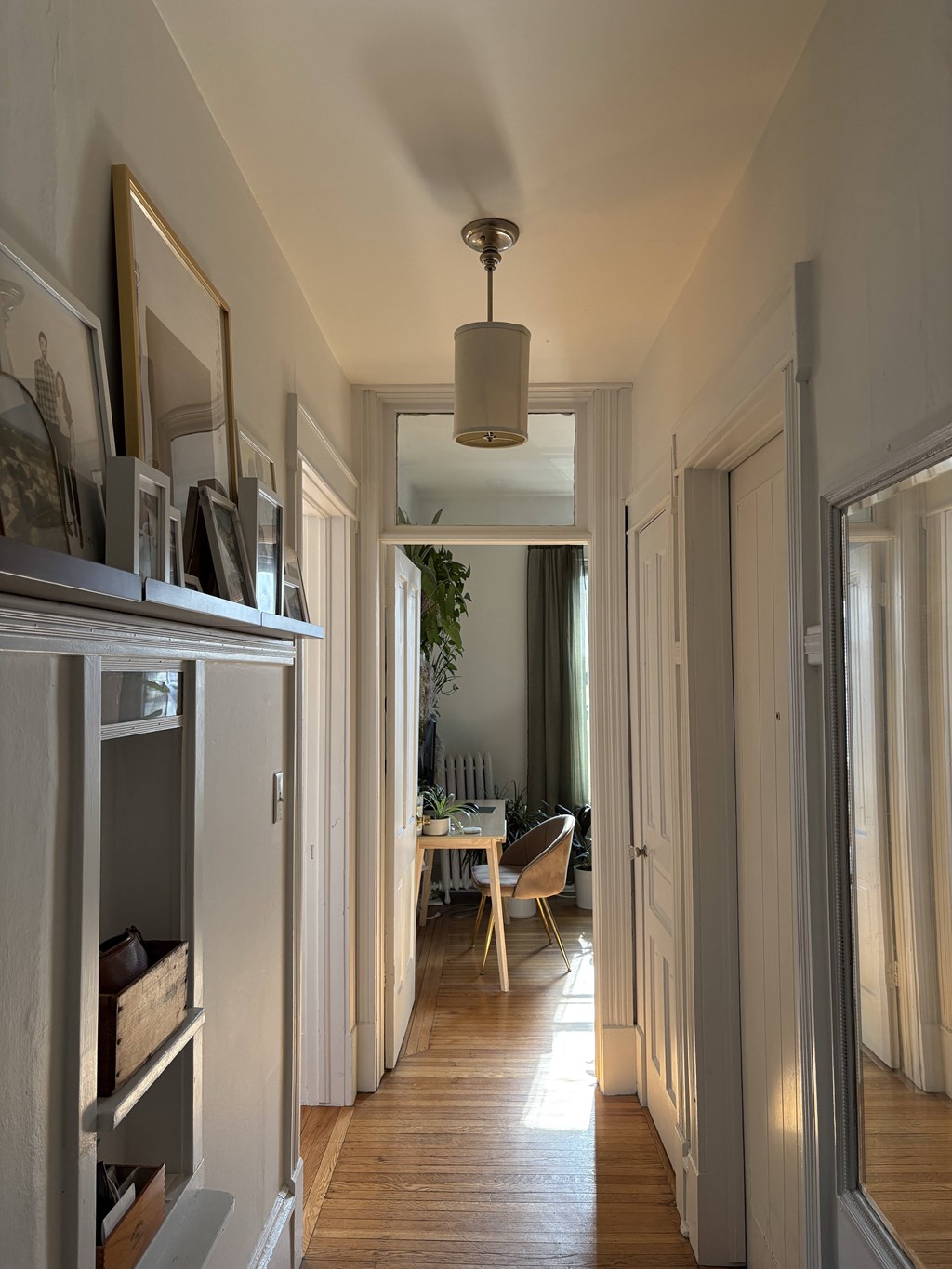 A long hallway with a table and chairs in the distance.