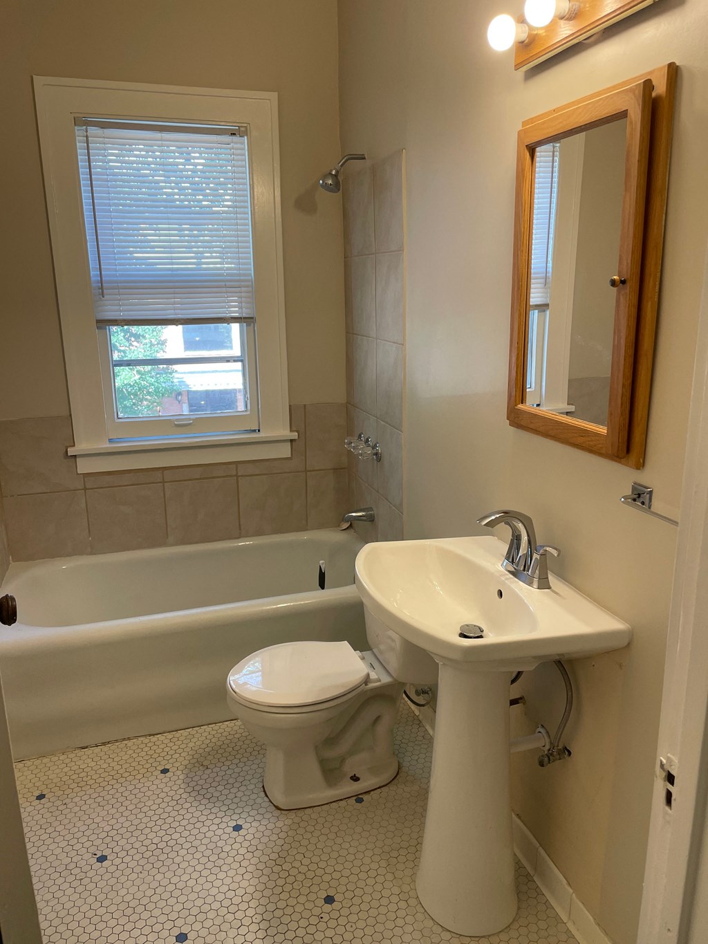 A white toilet sits next to a white sink in a bathroom.