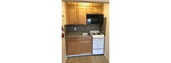 A kitchen with wooden cabinets and a white stove.