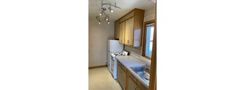 A kitchen with a white refrigerator and a sink.