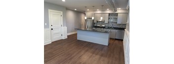 A kitchen with a white island and stainless steel appliances.