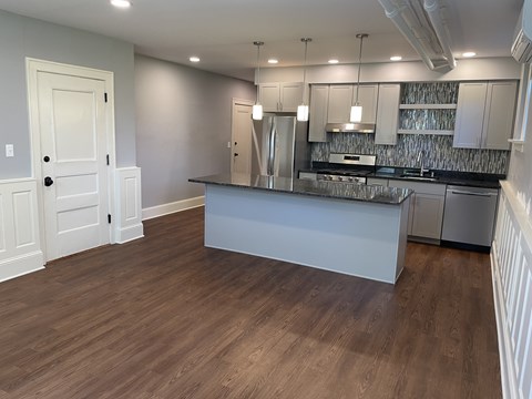 A kitchen with a white island and stainless steel appliances.