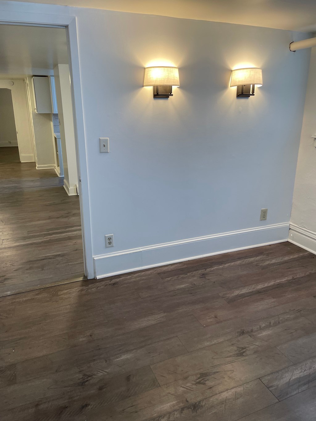 A room with a white wall and two lights on it.