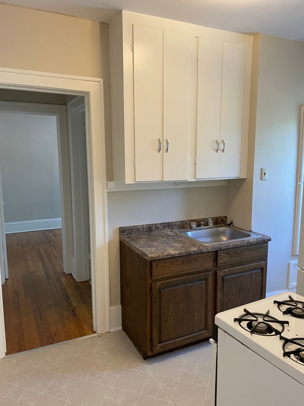 A kitchen with a white stove and wooden cabinets.