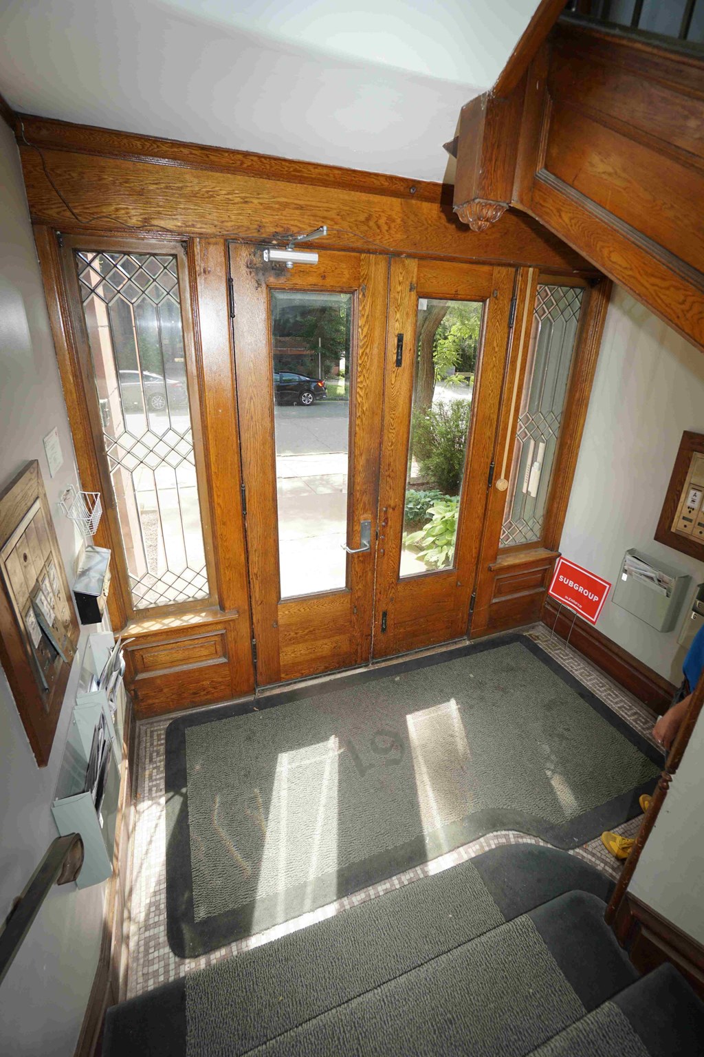 A wooden door with glass panels is flanked by two wooden posts.