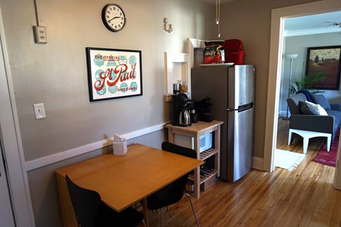 A kitchen with a table and chairs and a refrigerator.