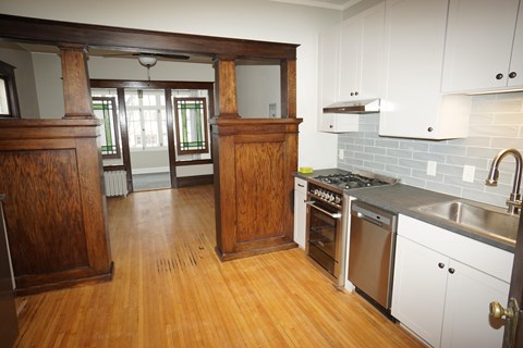 A kitchen with wooden cabinets and a white backsplash.