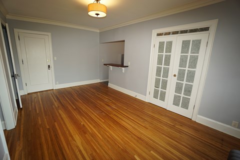 Spacious living room, warm hardwood floors, coved mouldings.
