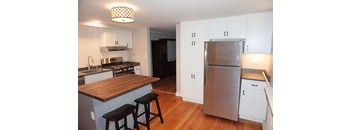 A kitchen with a wooden counter top and stainless steel appliances.