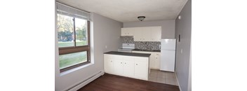 A kitchen with white cabinets and a black countertop.