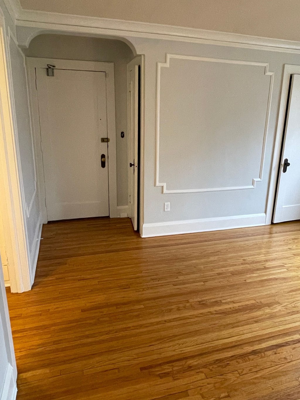 A room with wood flooring and white walls.