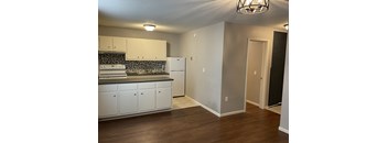 A kitchen with white cabinets and a black and white backsplash.