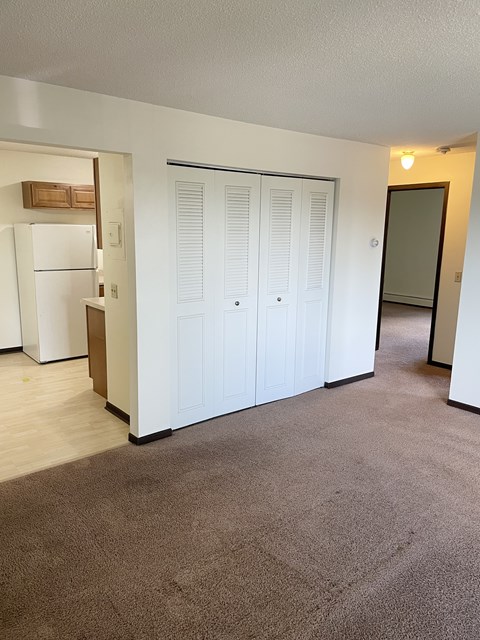 A white refrigerator is in a kitchen next to a white door.