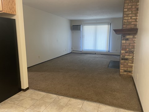 A room with a fireplace and a window with blinds.