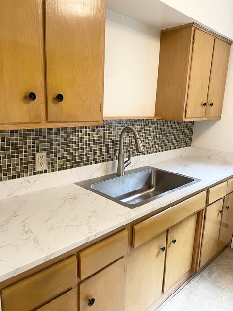 A kitchen with wooden cabinets and a sink.