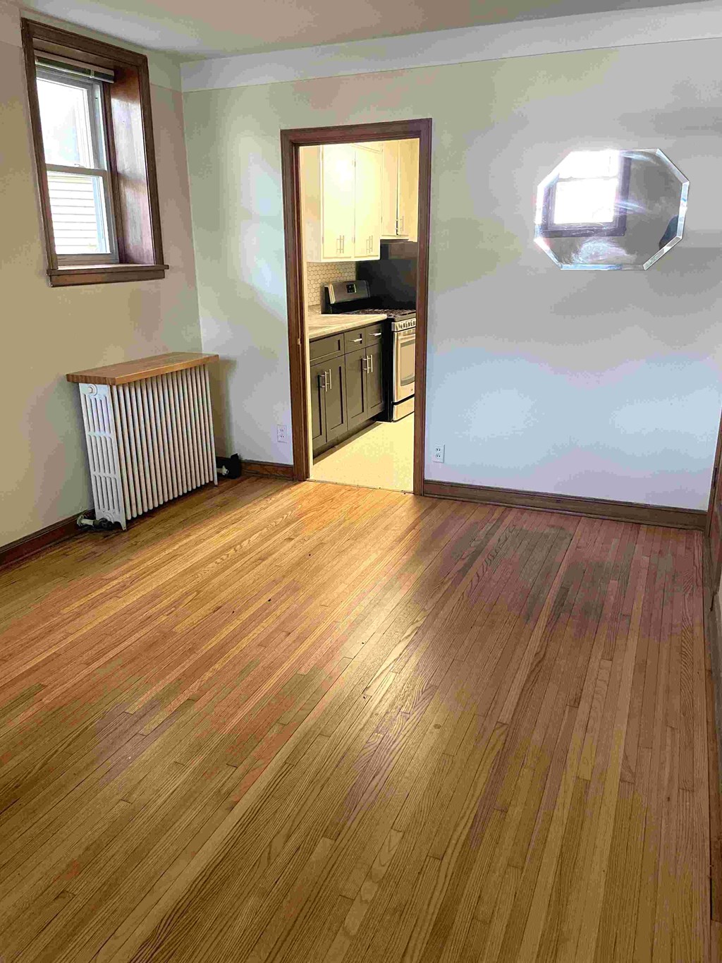 A room with wooden flooring and a window.