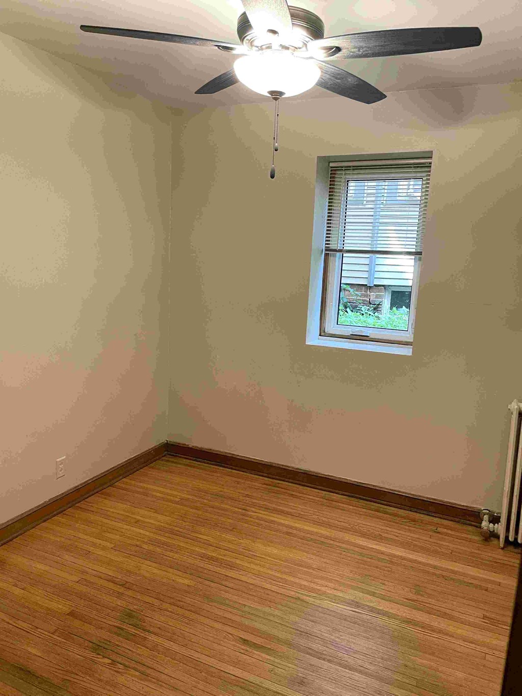 A room with a ceiling fan and a window.