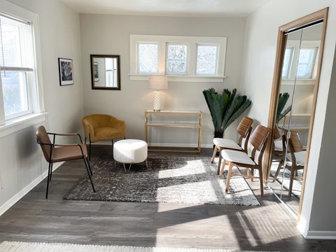 A living room with a brown chair and a white ottoman.