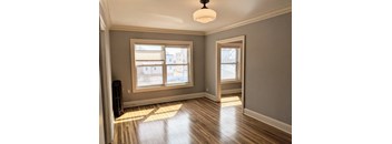 A room with wooden floors and a large window.