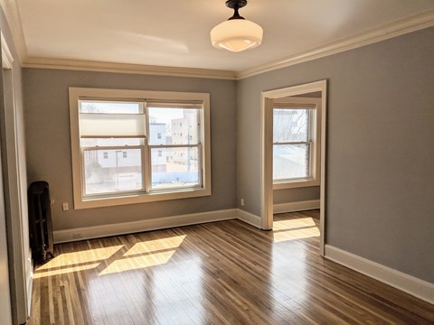 A room with wooden floors and a large window.