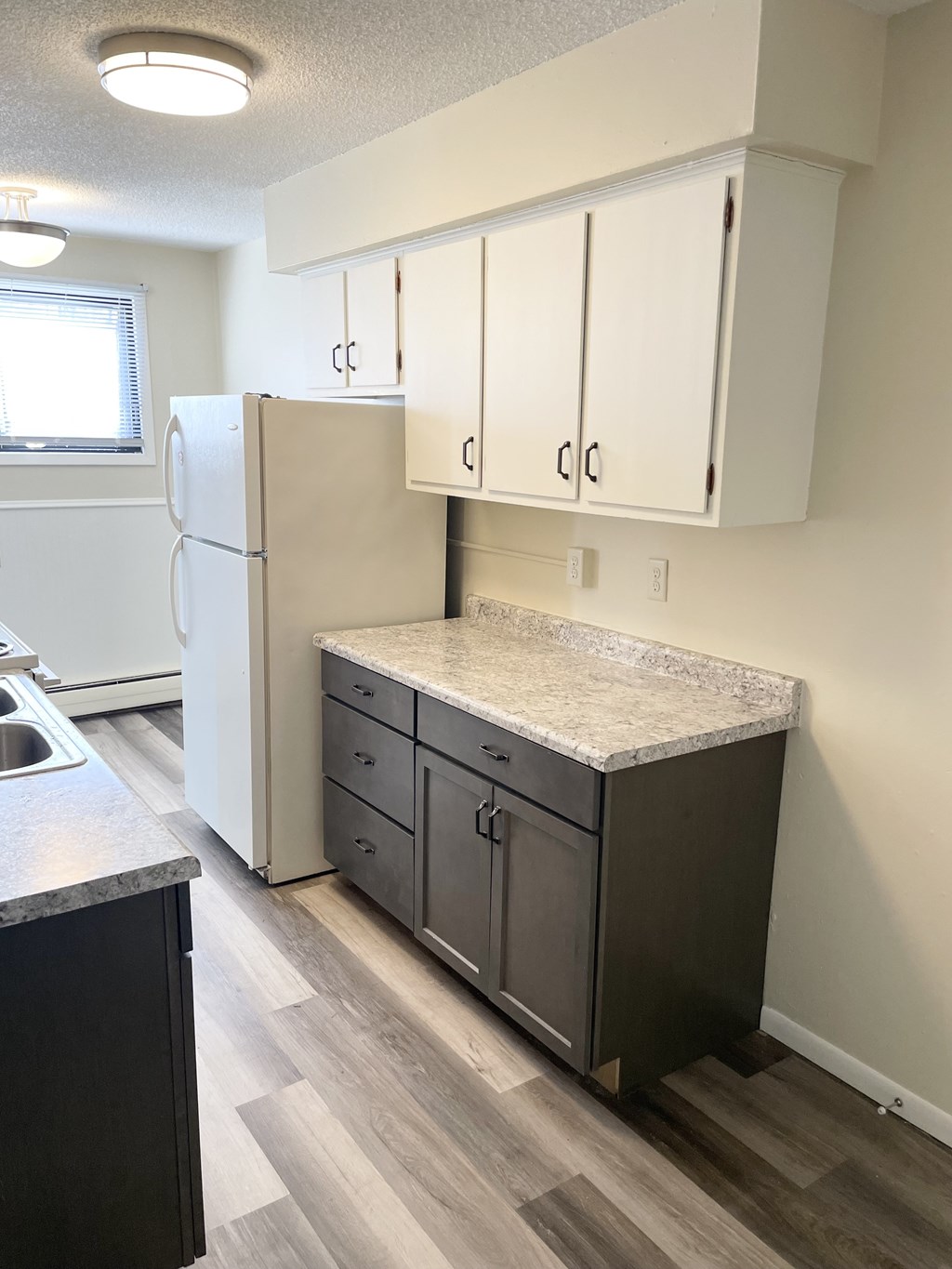 A kitchen with a white fridge and a black counter.