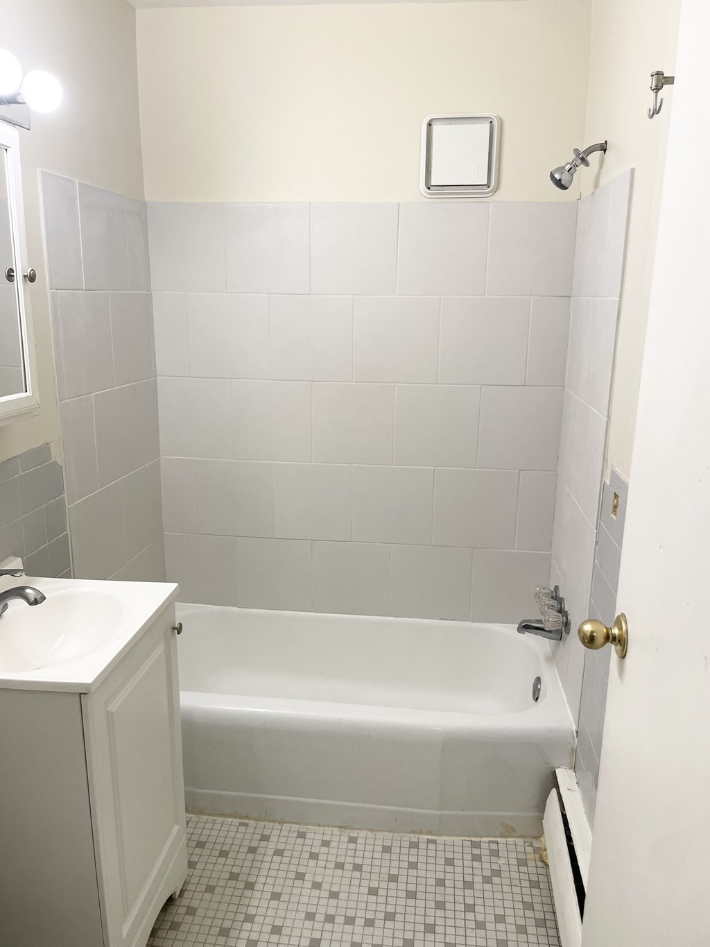 A white bathroom with a white tub and a white sink.